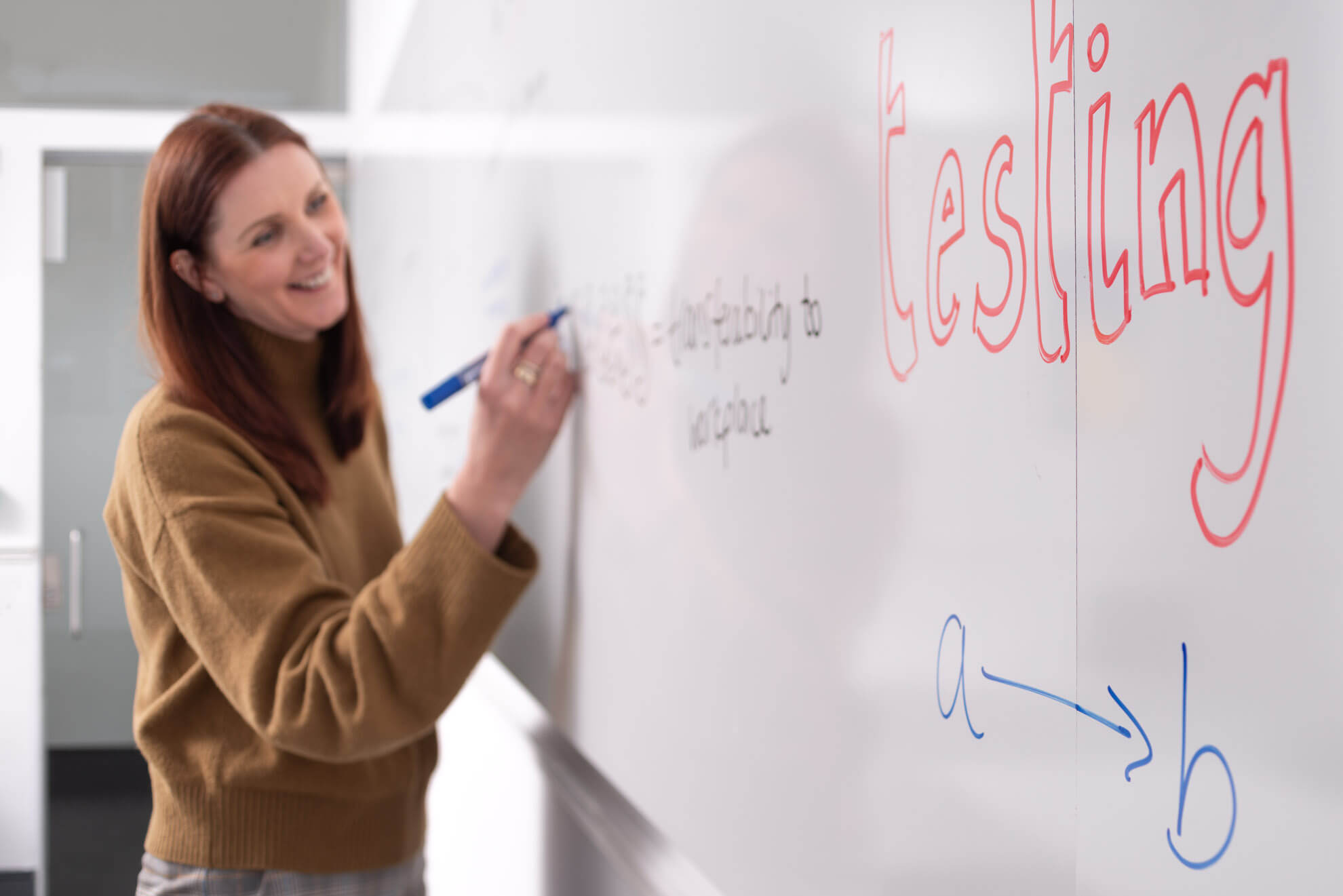 woman writes on giant whiteboard