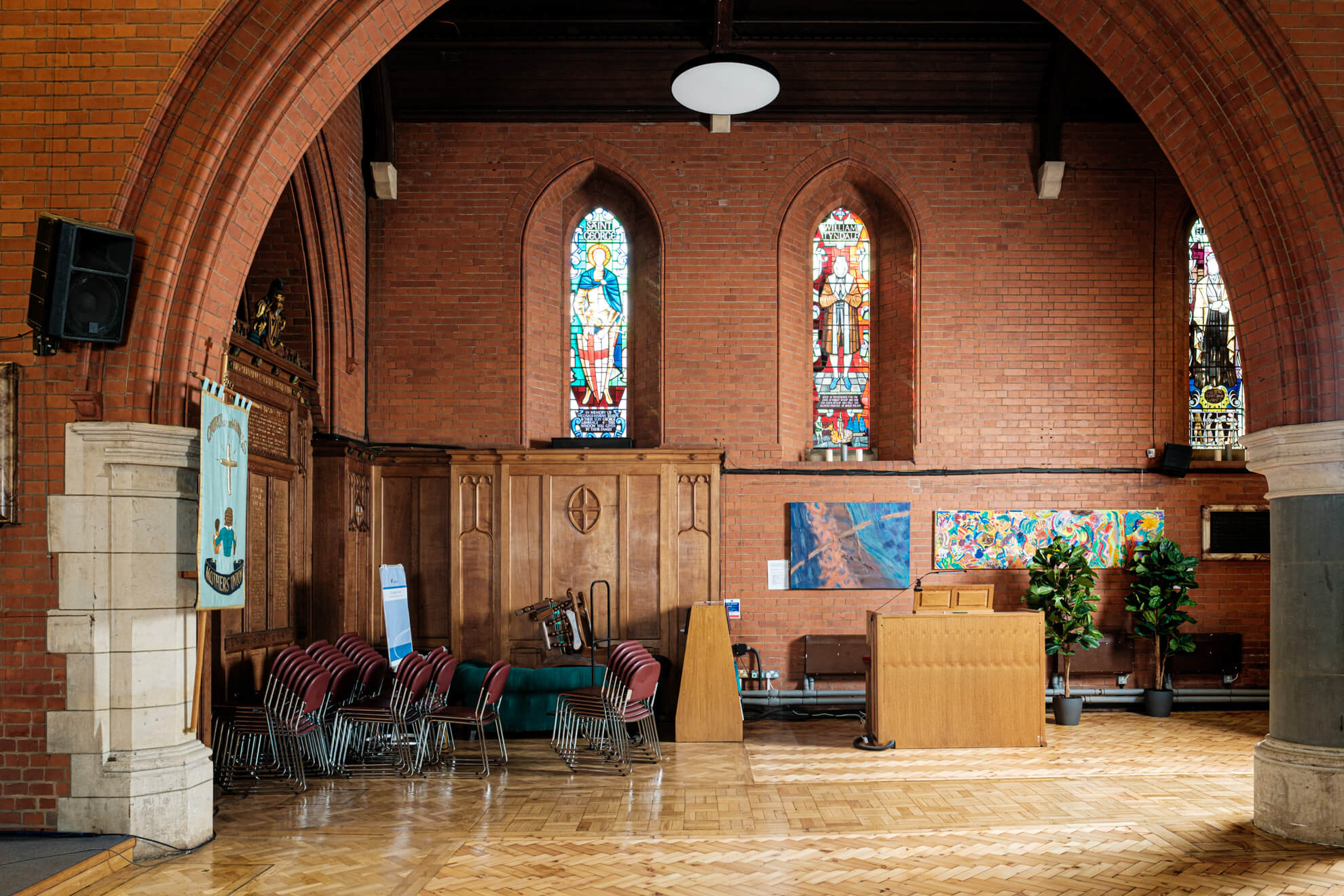 Stacks of chairs appear cluttered and messy in the corner of a church nave