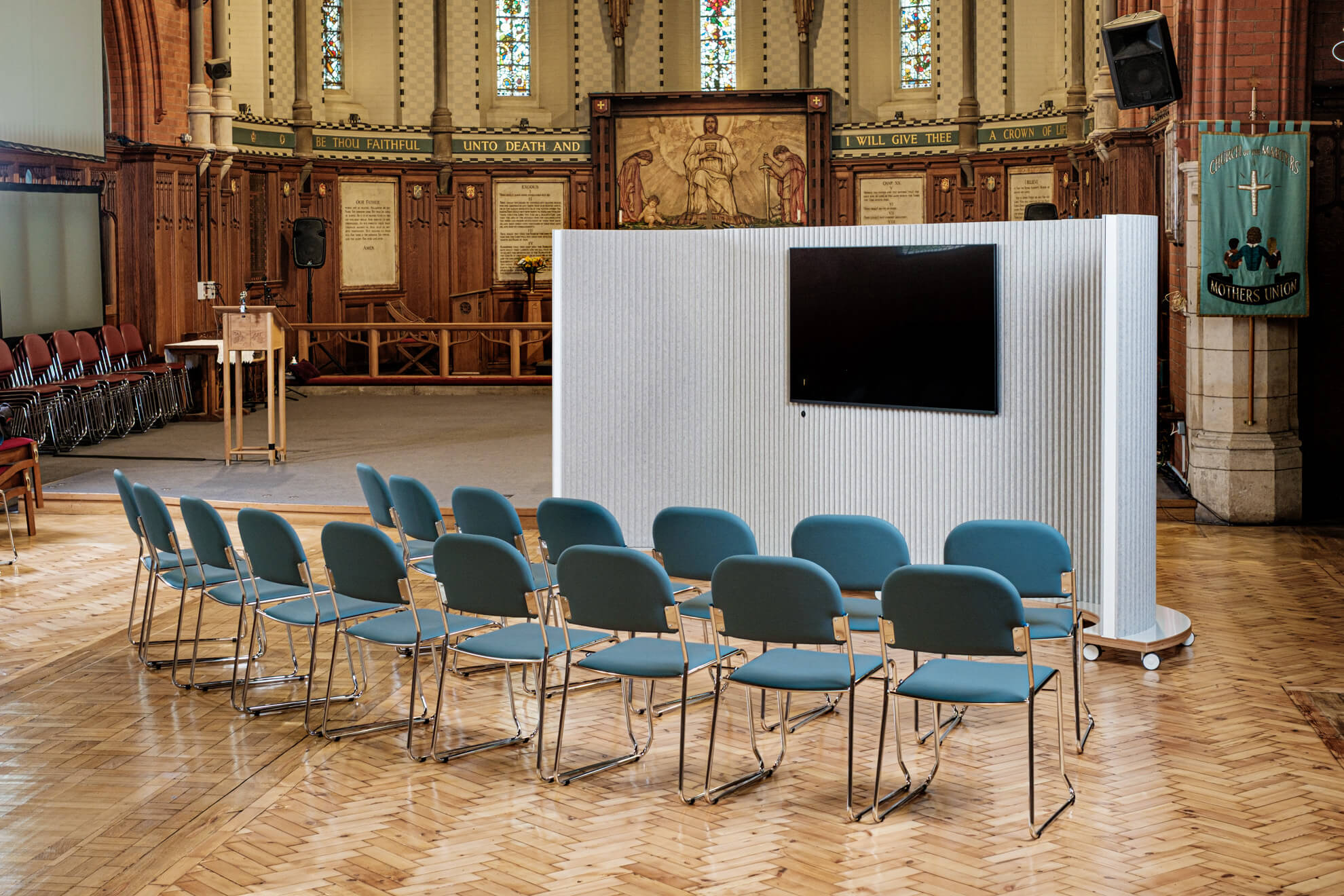 ThinkingWall partitioning including a TV screen creates a small meeting and teaching space in a church nave